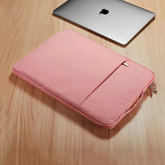 Pochette ordinateur portable rose avec doublure douce et poignée de transport posée sur un espace de travail.
